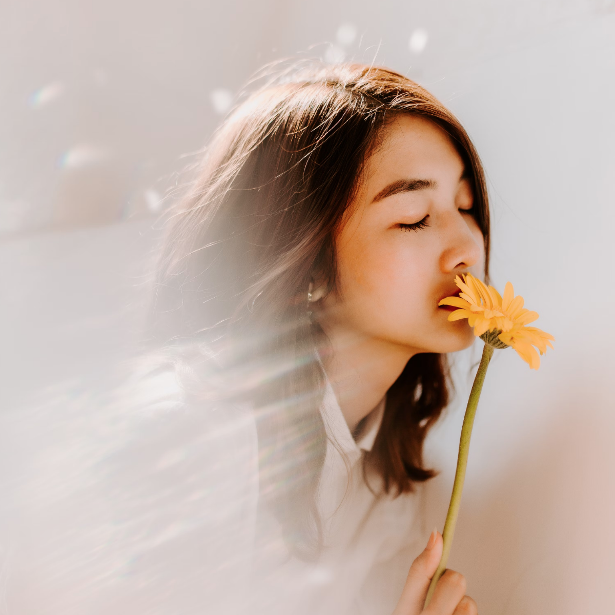 Young girl smelling a flower